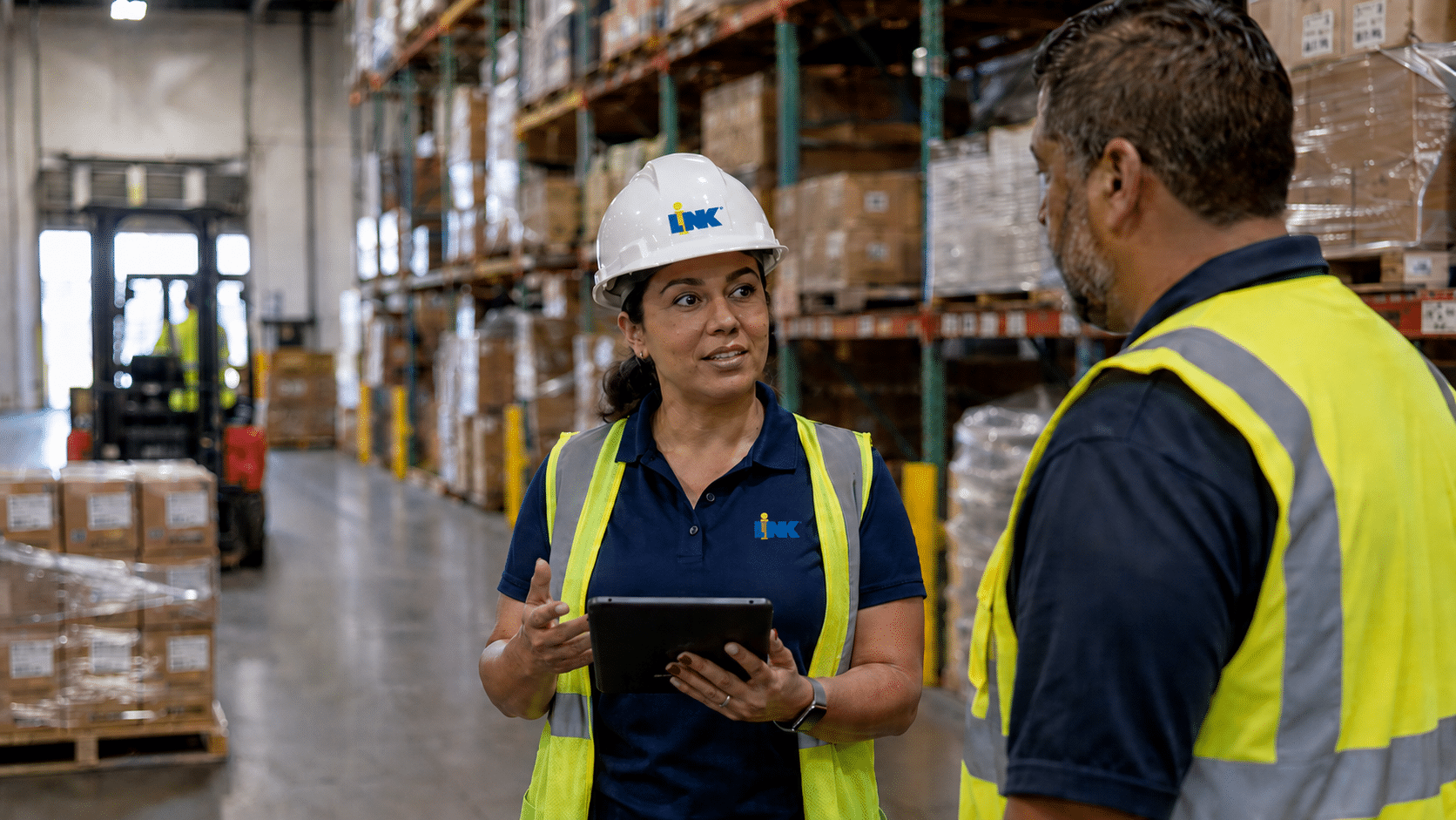 LINK on-site lead reviewing operations with a warehouse associate on a DFW distribution floor